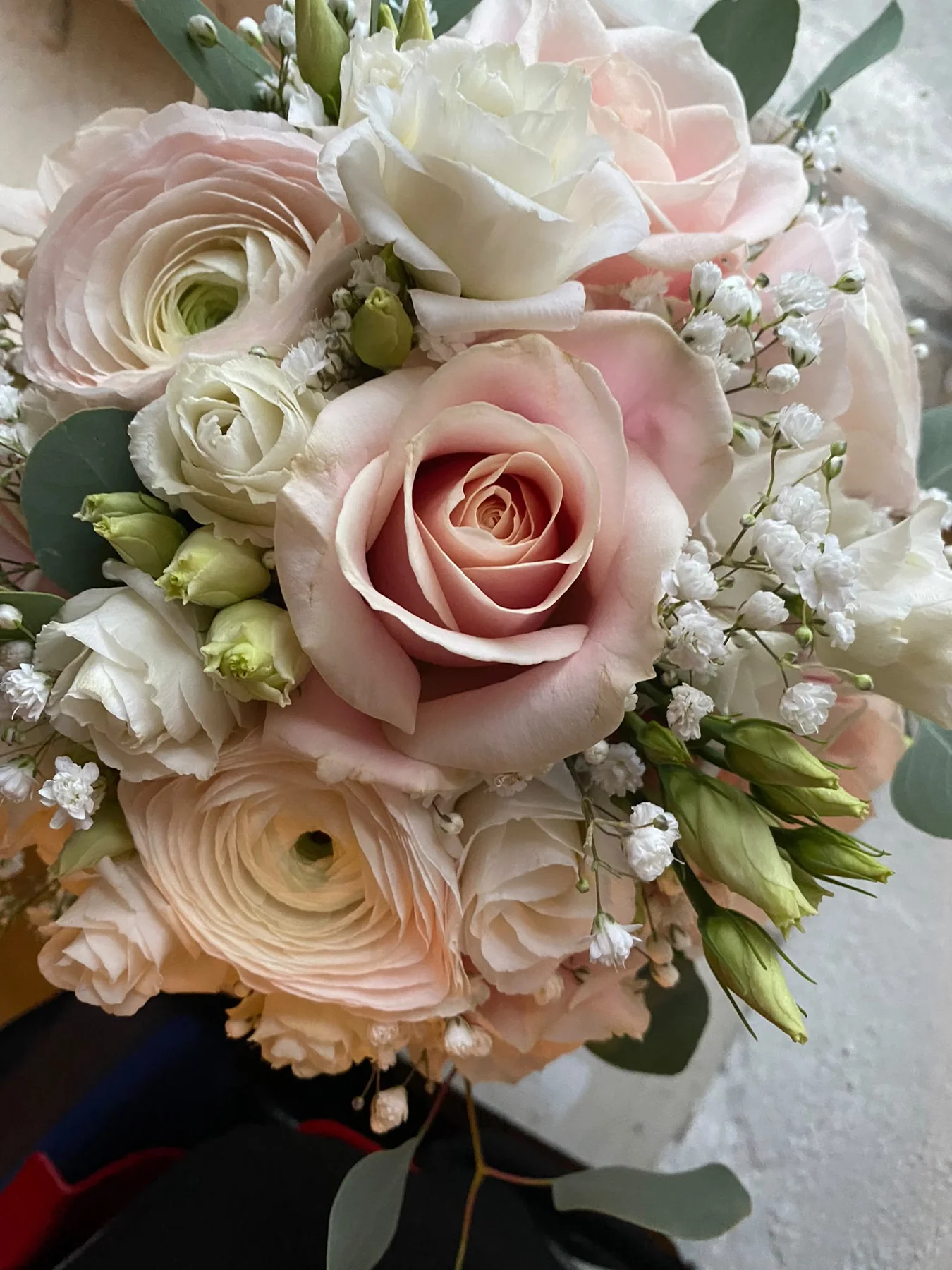 Nahaufnahme eines Brautstraußes aus rosafarbenen Rosen und Ranunkeln